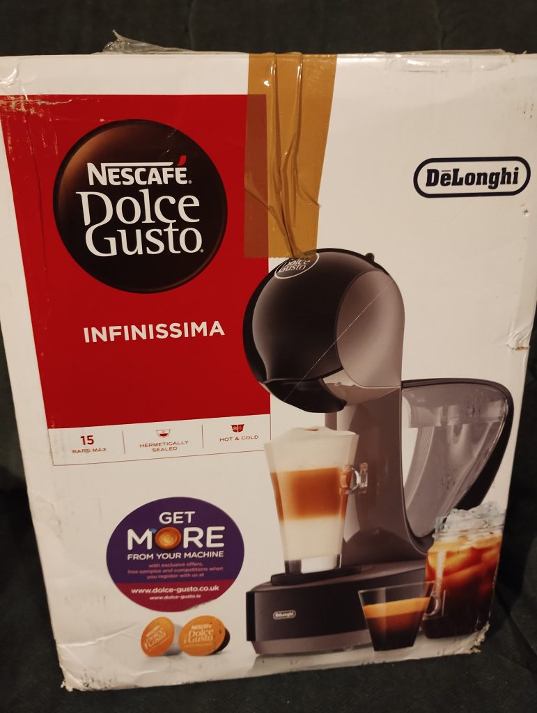 Dolce Gusto Infinissima coffee machine box, which is slightly damaged and has tape on it